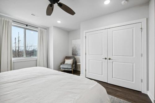 a white bedroom with a bed and a ceiling fan at Luxurious Condo with Rooftop and Parking near University City in Philadelphia