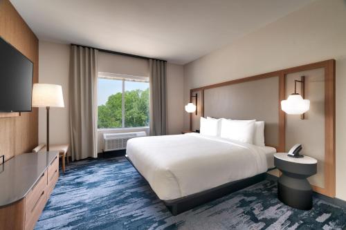 ein Hotelzimmer mit einem großen Bett und einem Fenster in der Unterkunft Fairfield by Marriott Inn & Suites Salt Lake City Cottonwood in Holladay