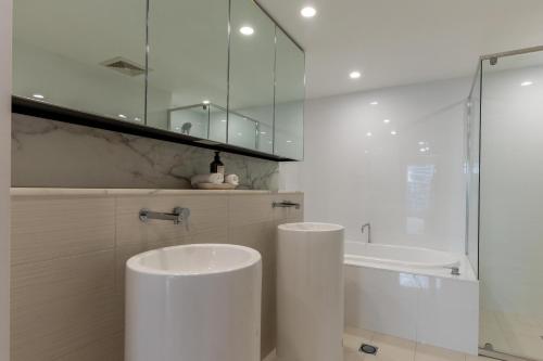 a white bathroom with a tub and a sink at Luxury Oracle Tower 1 Apartment 2Bed 2Bath 1 Car in Gold Coast