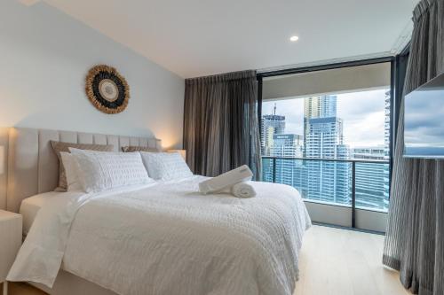 um quarto com uma cama branca e uma grande janela em Luxury Oracle Tower 1 Apartment 2Bed 2Bath 1 Car em Gold Coast