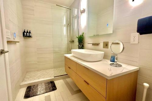 een witte badkamer met een wastafel en een douche bij Bright, airy, luxe hideaway”w” private backyard in Brooklyn
