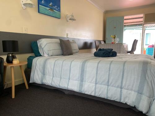 a bedroom with a bed with a blue and white comforter at Central Point Motel in Mount Isa