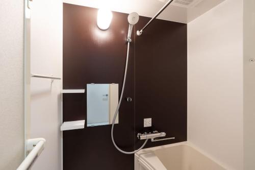 a bathroom with a light on a black wall at The Sanctus Ebisu in Tokyo