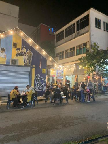 a group of people sitting at tables in front of a building at Andiana Hotel & Lodge - Kota Bharu City Centre in Kota Bharu