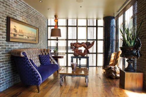 サバンナにあるThe Bohemian Hotel Savannah Riverfront, Autograph Collectionのリビングルーム(青いソファ、テーブル付)
