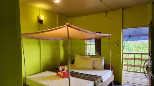 a bedroom with a bed in a green room at Sweet Jungle Bungalows in Koh Rong Island