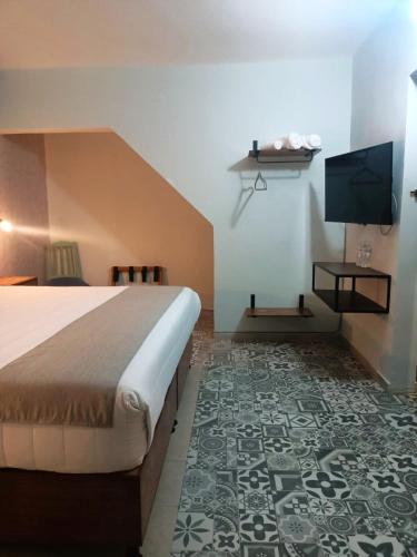 a hotel room with a bed and a flat screen tv at Añoranza Hotel Boutique in Ciudad Hidalgo