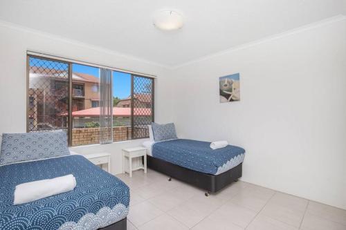 a bedroom with two beds and a window at Absolute beachfront apartment! in Gold Coast