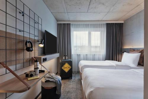 a hotel room with two beds and a window at Moxy Hamburg Altona in Hamburg