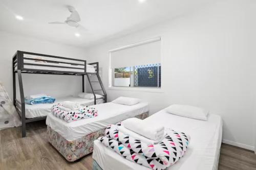 a bedroom with two bunk beds and a chair at Mermaid Beach Retreat in Gold Coast