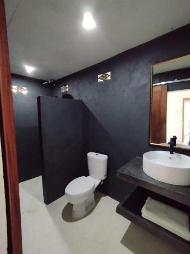 un bagno con un water bianco e un lavandino di Surfers Beachfront Lombok a Kuta Lombok
