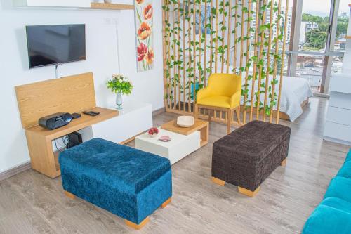 ein Wohnzimmer mit einem Sofa und einem TV in der Unterkunft Apartamento Loft Edificio Soho 905 in Armenia