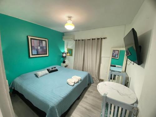 ein Schlafzimmer mit einem Bett und einer grünen Wand in der Unterkunft Temporarios Colón - Habitación Matrimonial in Posadas