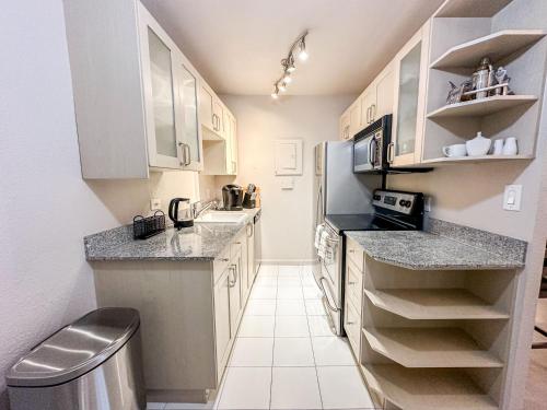 a kitchen with white cabinets and granite counter tops at 2BR Downtown Convention Center Near Attractions in Seattle