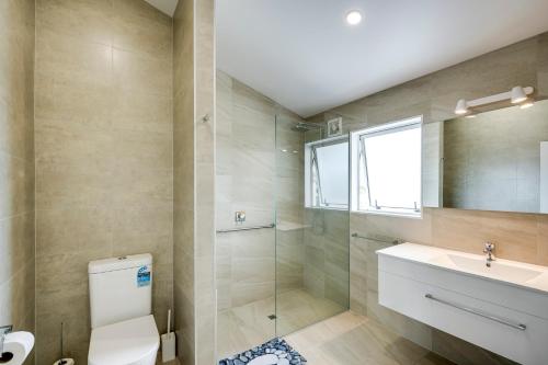 een badkamer met een toilet, een wastafel en een douche bij Marine Parade Beachfront - Napier Holiday Unit in Napier