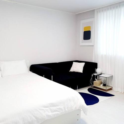 a white bedroom with a large bed and a couch at Stay Daewha Kintex 5min Daewha Station 5min Baek Hospital 1min in Goyang