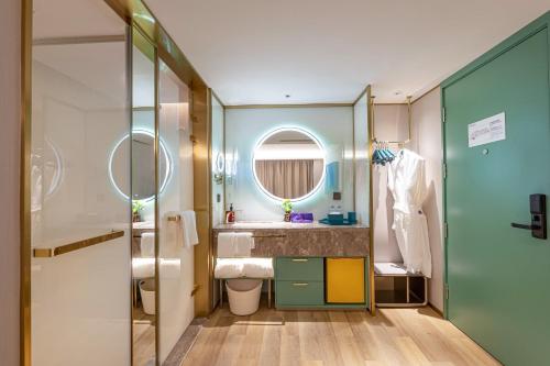 a bathroom with a sink and a mirror at Man Xin Zhangjiagang Pedestrian Street Hotel in Zhangjiagang