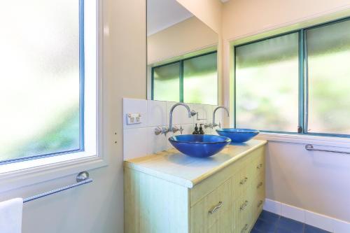 two blue sinks in a bathroom with windows at Ocean View Apartments by Kingscliff Accommodation in Kingscliff