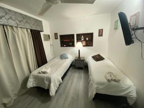 a room with two beds and a television in it at Temporarios Colón Habitación Céntrica 2 Camas in Posadas