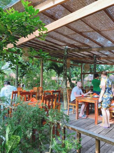 富国槟城侨海滩度假酒店的一组坐在木凉棚下的桌子上的人