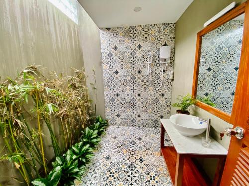 a bathroom with a sink and a shower with plants at Paksong Farmstay Gia Lai - Venuestay in Pleiku