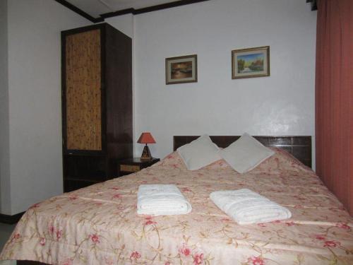 ein Schlafzimmer mit einem Bett mit zwei Handtüchern darauf in der Unterkunft Residencia Lourdes in Mactan