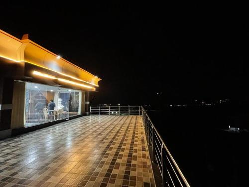 a person standing on the deck of a building at night at Dhruva Sky villament in Bidadi