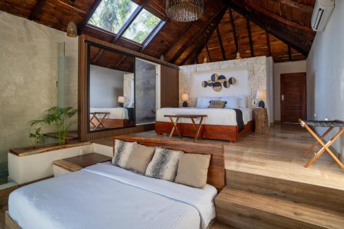 een slaapkamer met 2 bedden en een spiegel bij Xoot ka Ana luxury, Villa las Flores in Bacalar