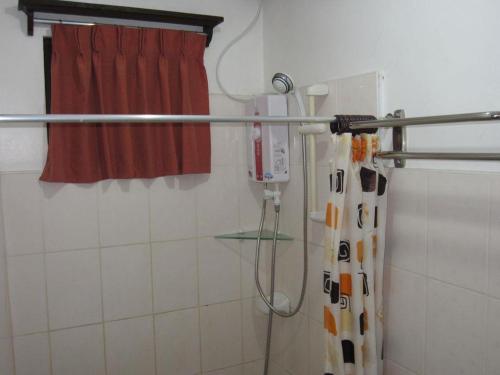 y baño con ducha y cortina roja. en Residencia Lourdes en Isla de Mactán