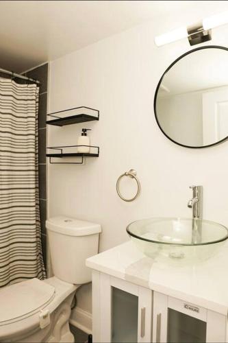 a bathroom with a sink and a toilet and a mirror at 1 Bed 1 Bath Suite in Washington, D.C.