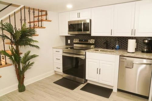a kitchen with white cabinets and a black stove at 1 Bed 1 Bath Suite in Washington