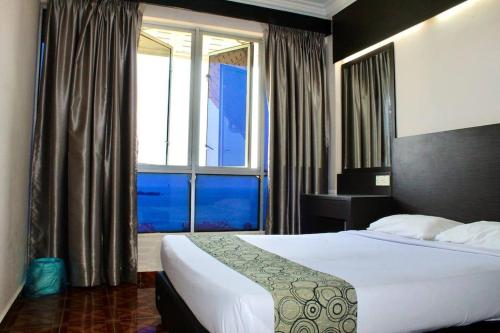 een slaapkamer met een groot bed en een raam bij D'Melor Penthouse Glory Beach Resort in Port Dickson