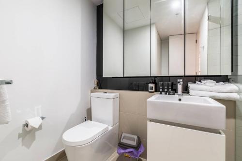 a bathroom with a white toilet and a sink at Effortless Local Living on Greville Street in Melbourne