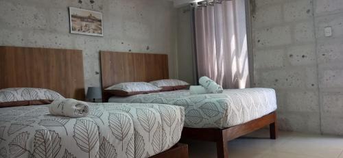 a bedroom with two beds and a window at Hotel Mutua FAP in Arequipa