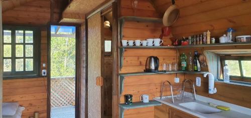 een keuken met een spoelbak in een houten hut bij Aldeia Ananda Imbituba in Imbituba