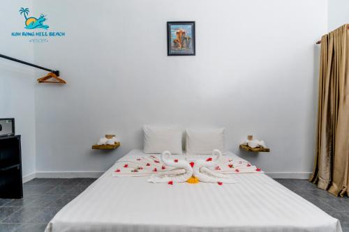 a bedroom with a bed with white sheets and flowers on it at Koh Rong Hill Beach Resort in Koh Rong Island