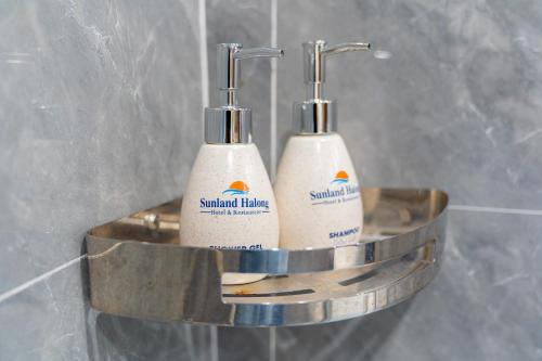 two toothbrushes in a metal holder in a bathroom at Sunland Halong Hotel and Restaurant in Ha Long