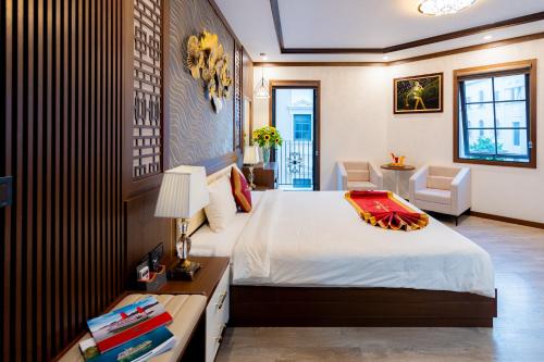 a bedroom with a bed and a desk with a lamp at Sunland Halong Hotel and Restaurant in Ha Long