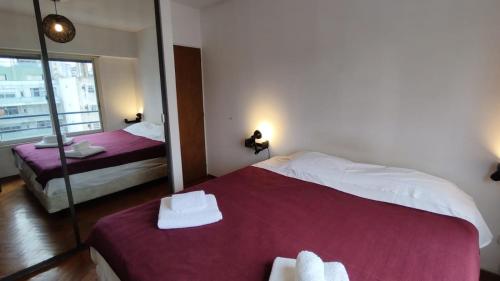 um quarto de hotel com duas camas e um espelho em Cozy apartment in Palermo - La Rural em Buenos Aires