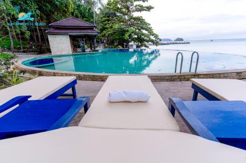 a table with a napkin on it next to a swimming pool at Koh Rong Hill Beach Resort in Koh Rong Island