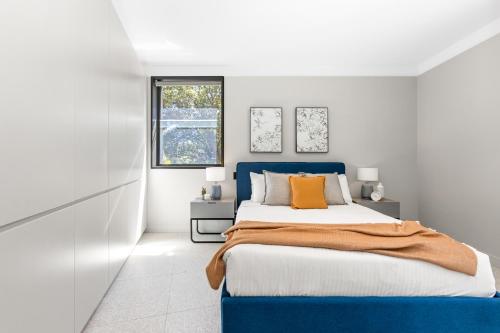 Un dormitorio con una cama azul y una ventana en The 249 Apartments by Urban Rest en Sídney