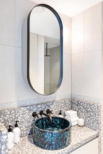 a bathroom with a sink with a mirror at The 249 Apartments by Urban Rest in Sydney