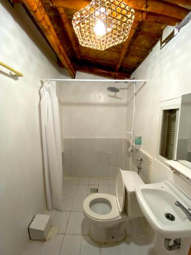 Tibiao的住宿－Kasa Raya Inn，浴室配有白色卫生间和盥洗盆。