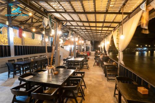restauracja z drewnianymi stołami i krzesłami oraz rzeką w obiekcie Koh Rong Hill Beach Resort w mieście Koh Rong