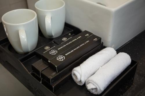 una bandeja negra con dos tazas y dos toallas en Madelise Adora Hotel & Travel en Hanói