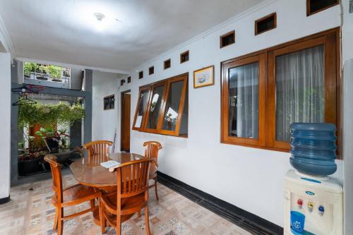 a dining room with a wooden table and chairs at House Of M Bogor Mitra RedDoorz in Bantarkamang