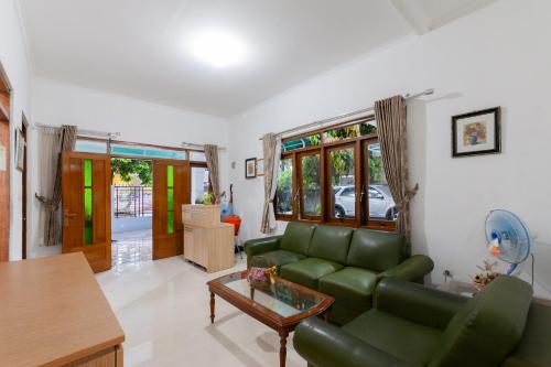 a living room with a green couch and a table at House Of M Bogor Mitra RedDoorz in Bantarkamang