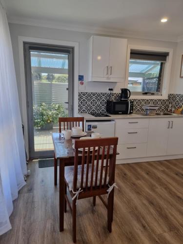 a kitchen with a table and two chairs and a table at Kadi House - Unit 1 in Wynyard