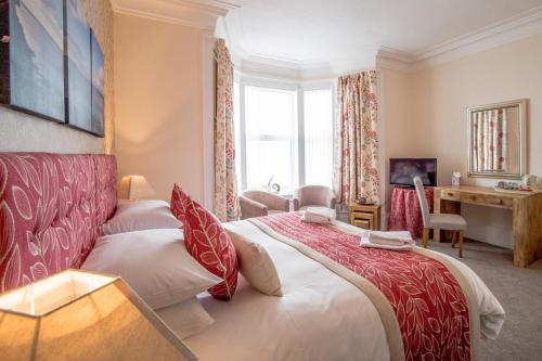 a hotel room with a large bed and a desk at Craignelder Hotel in Stranraer