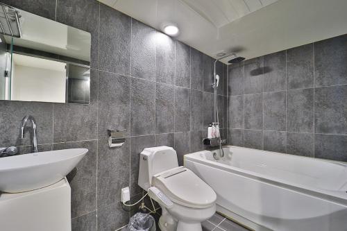 a bathroom with a white toilet and a sink at Anyang ILLOWA Hotel in Anyang